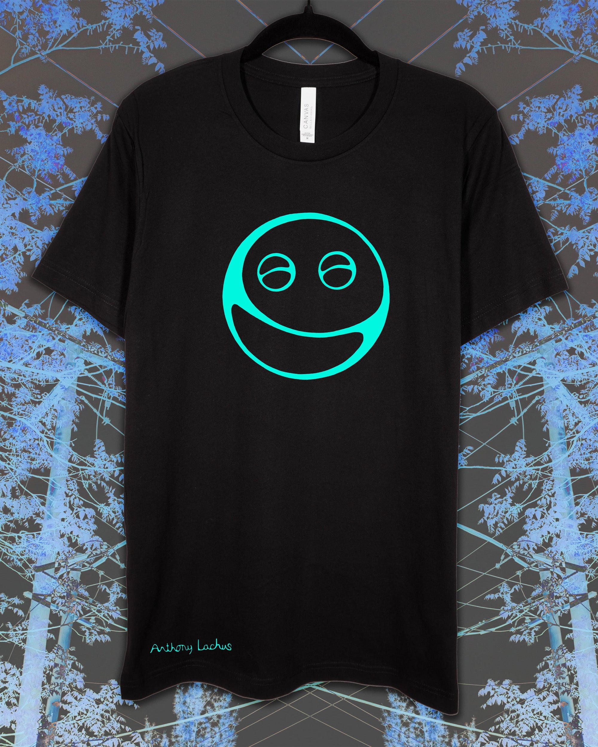 Black t-shirt with a green smiley face design on a textured blue and gray background