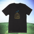 Black t-shirt with birdcage and bird design on a grassy field background