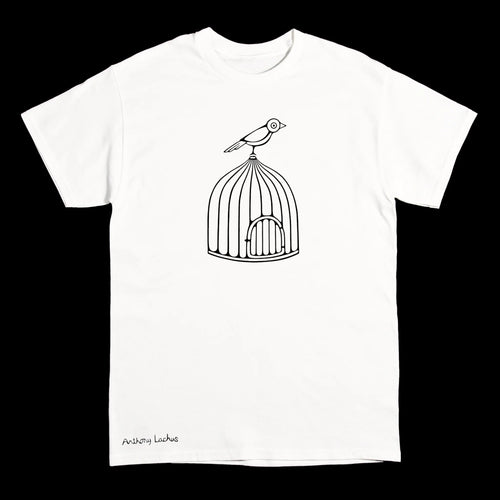 A white short-sleeve crewneck t-shirt featuring a black line art graphic of a bird perched on top of a birdcage, with the text 'Anthony Lachus' printed in black near the bottom left hem, shown against a solid black background. An original, hand drawn artwork by Anthony Lachus.